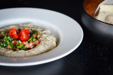 lebanese hummus dish with fresh vegetables, beef meat & pomegranate seeds