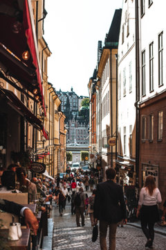 STOCKHOLM, SWEDEN - AUGUST 26, 2013: People walk along Tyska Brinken Street. Cozy cafes. Gamla Stan Old Town View