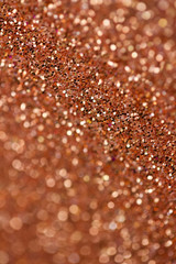 Sparkling copper glitter texture abstract background with bokeh