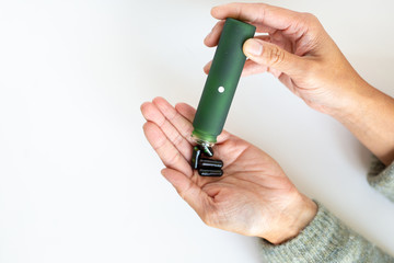 Vitamin Supplements in Green Jar Poured in Hand