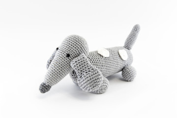 Gray dog (dachshund), knitted toy. Isolated on white background