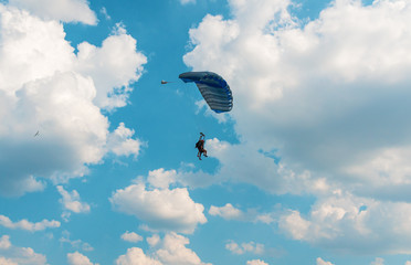 Two men flying in the blue sky using parachute