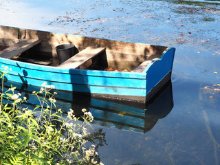 Blue and small wood boat parked in a river.