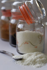 Coconut powder in glass jar on white background.