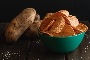 Set of french fries on wooden table and black background