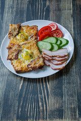 Grilled sandwich with egg, vegetables and bacon on a dark wooden background. Tasty breakfast.