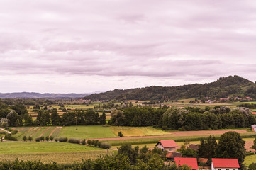 Green hills and an old village in Slovenia. Traveling in Europe and tourism. Nature, sky and vineyards.