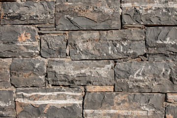 Texture of a stone. Old stone wall texture background. Grey stone wall as a background or texture. Stone wall of natural stones in different sizes. Side covering with natural stones.