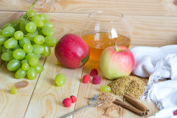 Vegan food ingredients. Flax seeds, scattered raspberries, cinnamon sticks, apples, grapes.