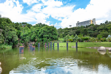 Lake in a public outdoor park surrounded by green trees and exercise toys in Jundiai, Sao Paulo, Brazil