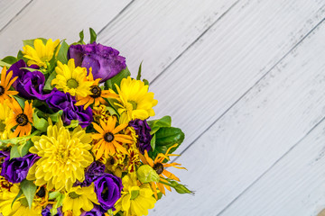 close - up of colorful beautiful spring bouquet isolated on white wooden background. Bright purple and yellow flowers. Decorative composition for the holiday mother's day and birthday. Copy space