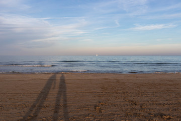 Mediterranean  sunset with sailboats in Valencia from the beach