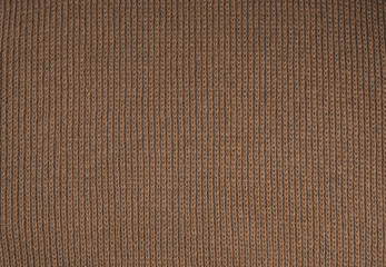 Fototapeta na wymiar Autumn background from brown knitted wool close-up