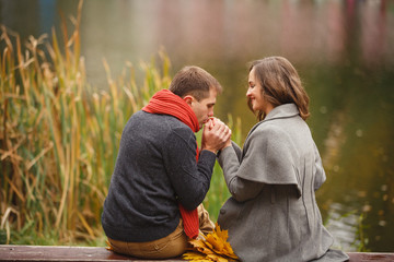Two lovers in autumn park look on each other with love and tenderness. couple on autumn walk...