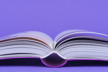 Open book closeup on blank purple background