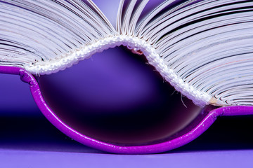 Open book hardcover close-up on violet background