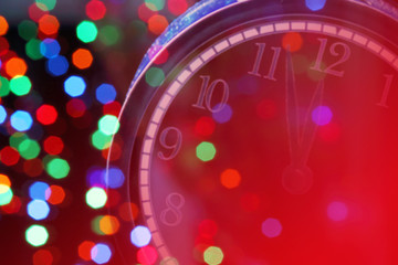 New year clock on blurred Christmas background with bokeh. Minutes about New year, minimal style, postcard, copy space.