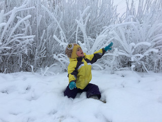 Fototapeta na wymiar kid reaches up in a snowy forest