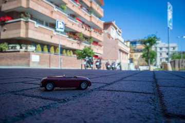 Classic toy car in the street, pretending to be real.