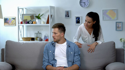 Nervous woman criticizing lazy husband sitting on sofa, family conflict, problem