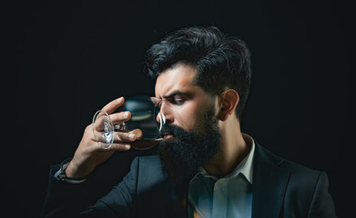 Confident well-dressed man with glass of whisky. Bearded and glass of whiskey.