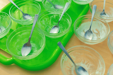 Empty dirty plates with spoons on a bright green tray.