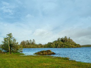 Simple landscape, Small island in a lake Corrib, Ireland, Cloudy blue sky,