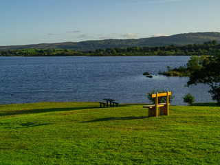 Wooden seat with beautiful view on Lough Corrib, Ireland, Blue water surface, Cloudy sky. Relaxed atmosphere, Nobody.