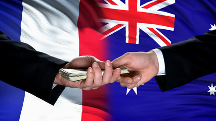 France and Australia officials exchanging money, flag background, financial help