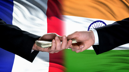 France and India officials exchanging money, flag background, cooperation