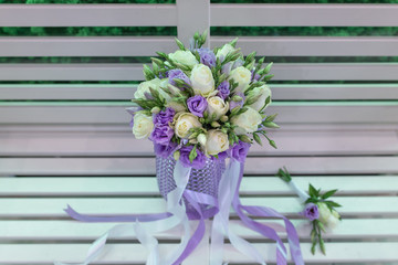 Sensual bright bouquet of fresh flowers with ribbons on the background of a white bench (Flowers: rose, Eustoma. Primary colors: white, blue)