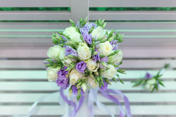 Sensual bright bouquet of fresh flowers with ribbons on the background of a white bench (Flowers: rose, Eustoma. Primary colors: white, blue)