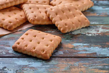 Tasty square cookies on a wooden table.