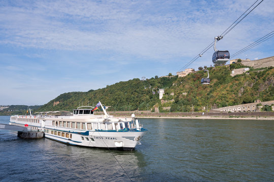 KOBLENZ, GERMANY - September 2, 2016: river cruise ship SWISS PEARL with Rhine cable car and Fortress Ehrenbreitstein in the background. SWISS PEARL has a capacity of 123 passengers.