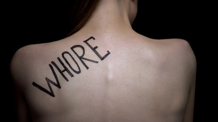 Insecure naked female showing word whore on shoulder, public humiliation - obrazy, fototapety, plakaty