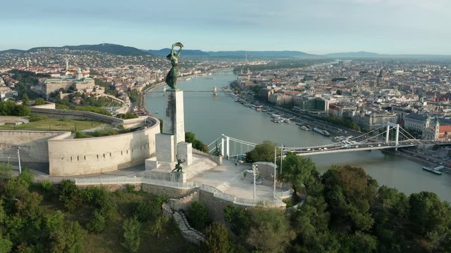 flying past Liberty Statue towards daytime view of Budapest
