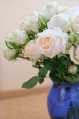 A bouquet of fresh tea and gently pink roses on a beige background.