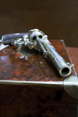 Antique pistol, revolver on wooden table
