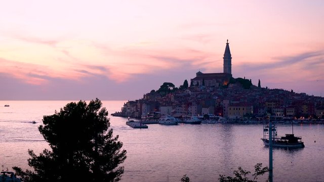 Colorful cloudy sunset over the old town Rovinj with harbor and boats in the sea, Croatia