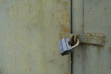 A padlock on a metal rusty gate.