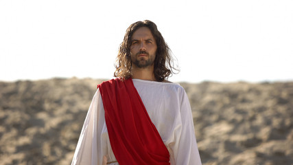 Jesus looking at camera, preaching Christian faith in desert, soul salvation