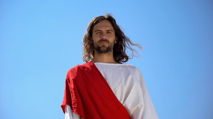 Cheerful god Jesus smiling into camera from heaven, concept to enjoy life