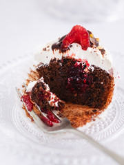Chocolate muffins, cupcake cut in half with fresh raspberries and raspberry jam on the table, light background with space text. Selective focus.