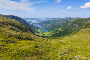 Naklejka premium tourist hiking on a sunny summer day on the nature of mountain norway