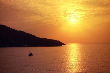 Beautiful sunset over Aegean sea with some clouds and golden colours