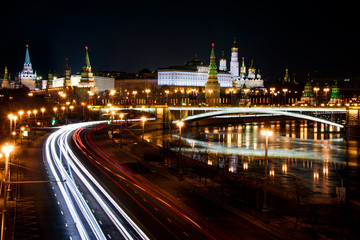 Fototapeta na wymiar Moscow's Kremlin by night with light trails of cars in the street on the embankment of the Moskva river