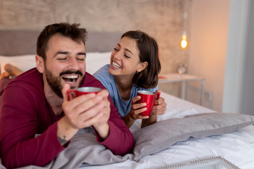 Couple having morning coffee in bed