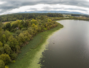 Fototapeta na wymiar Iridescent aerial photography of breathtaking Harts Lake from Pierce County in Roy, Washington
