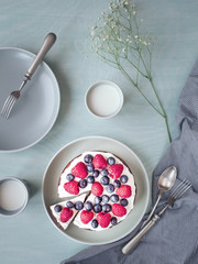 Homemade cake from cocoa, whipped cream and berries. Overhead shot.