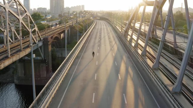Aerial drone view of cyclist riding over the bridge